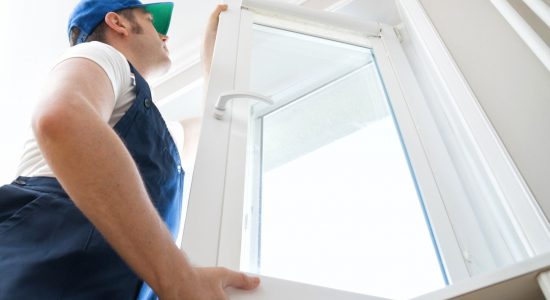 Professional handyman installing window at home. Professional handyman installing window at home.